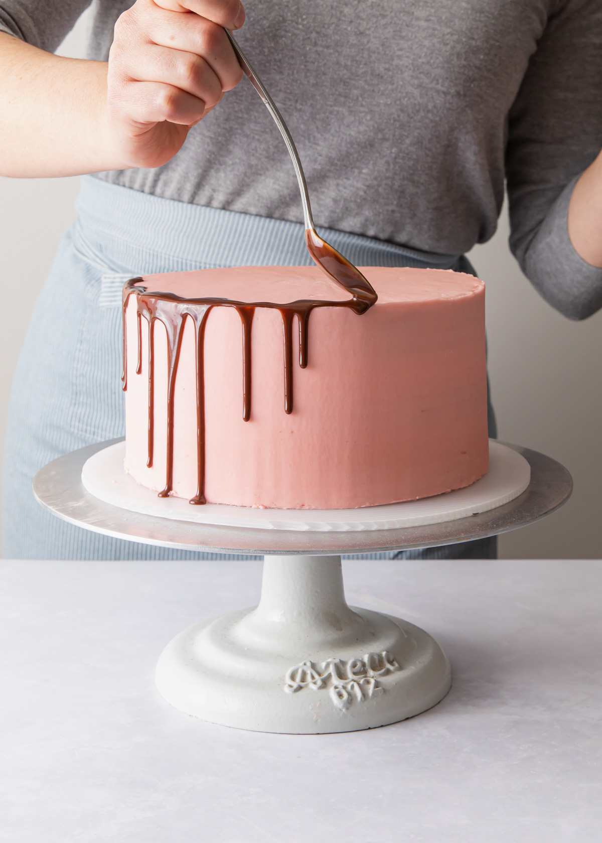 Adding drips of chocolate around the edge of a cake