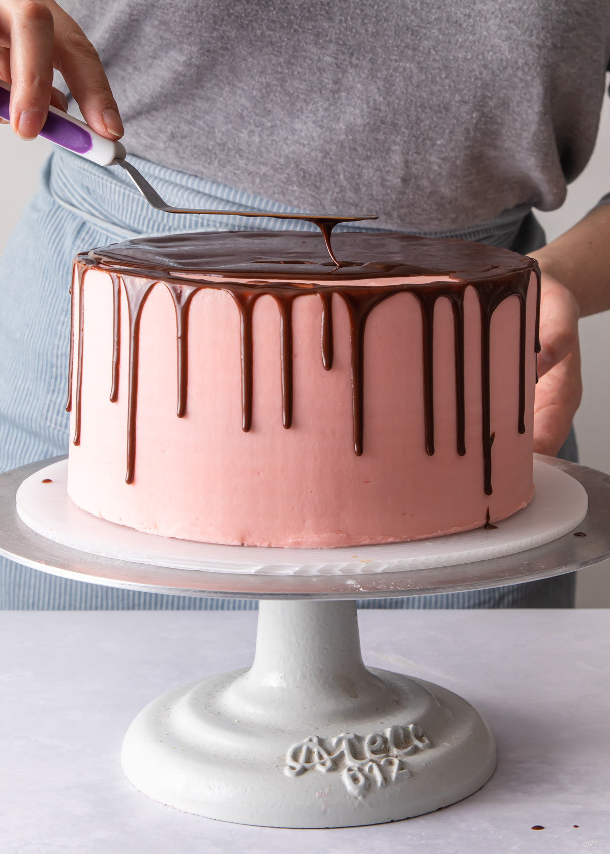 Smoothing out chocolate glaze with an offset spatula