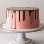 a perfect chocolate drip cake with pink buttercream frosting