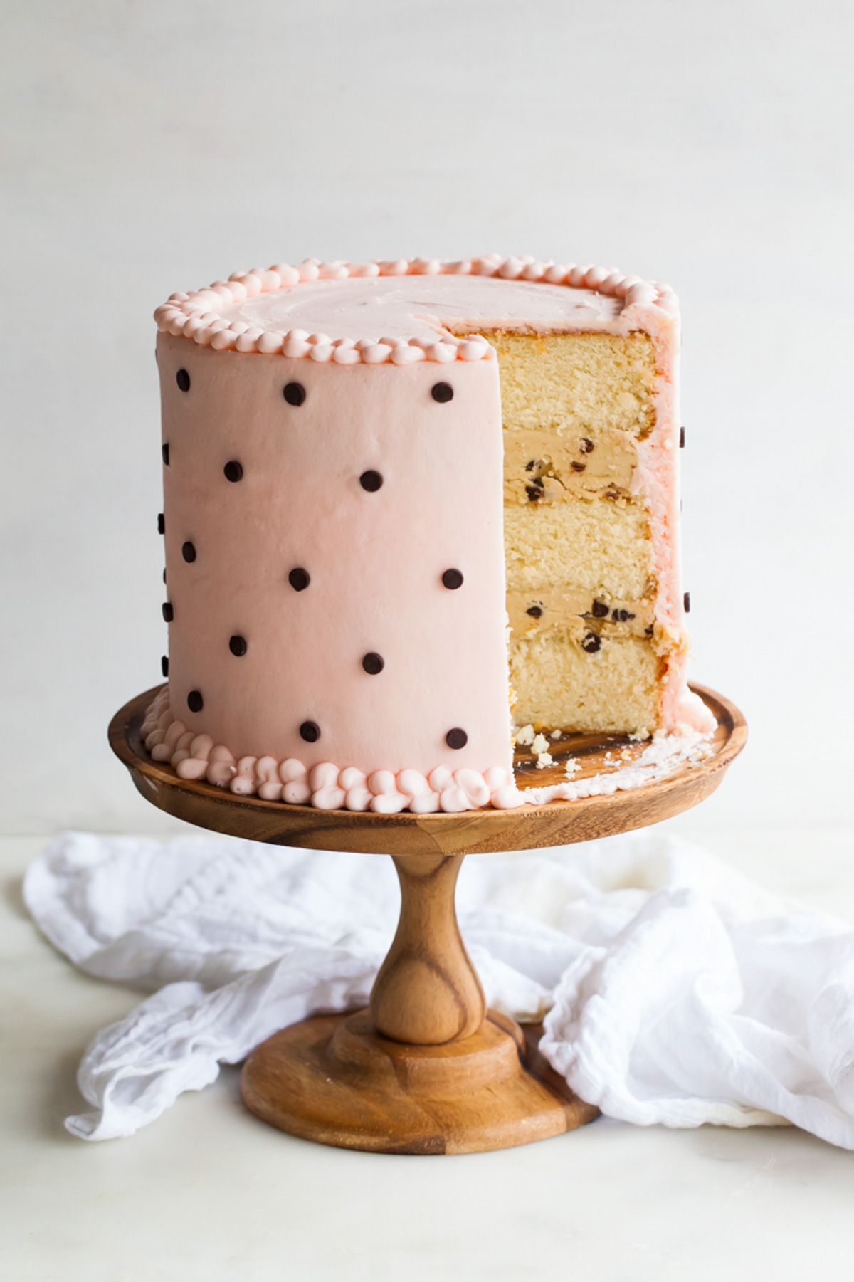 A milk and cookies cake that's been sliced with cookie dough filling