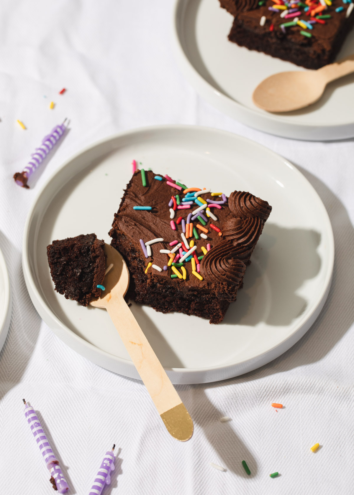 A slice of easy chocolate sheet cake with fudge frosting and sprinkles