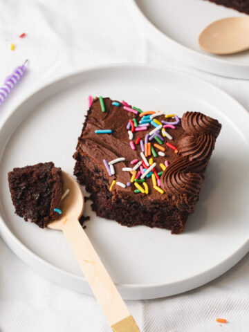 A slice of sheet cake with chocolate frosting