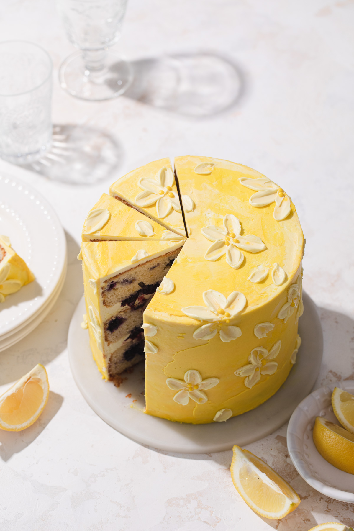 A lemon blueberry layer cake with buttercream daisies on top