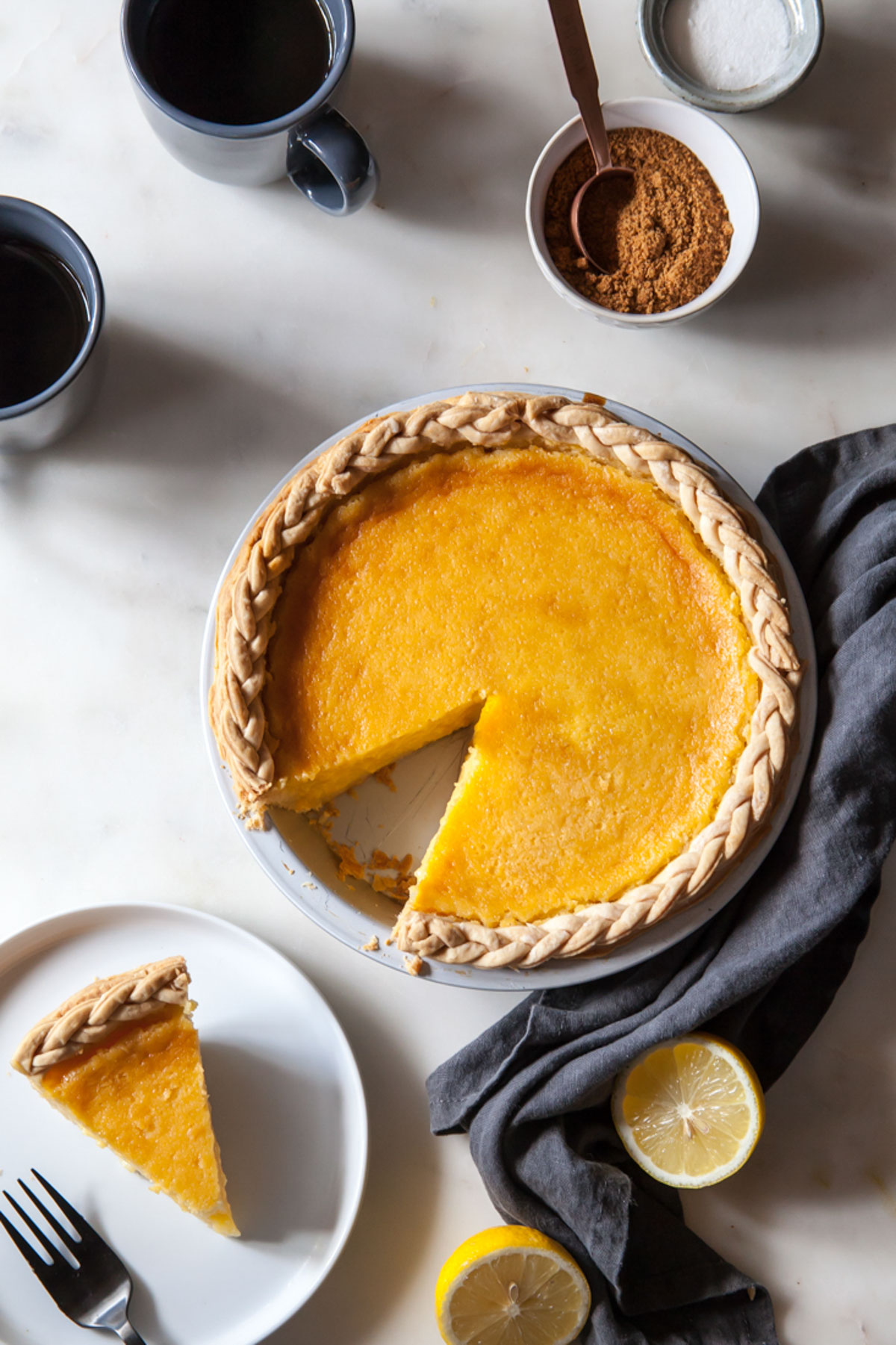 An overhead image on a baked lemon chess pie with a slice cut out