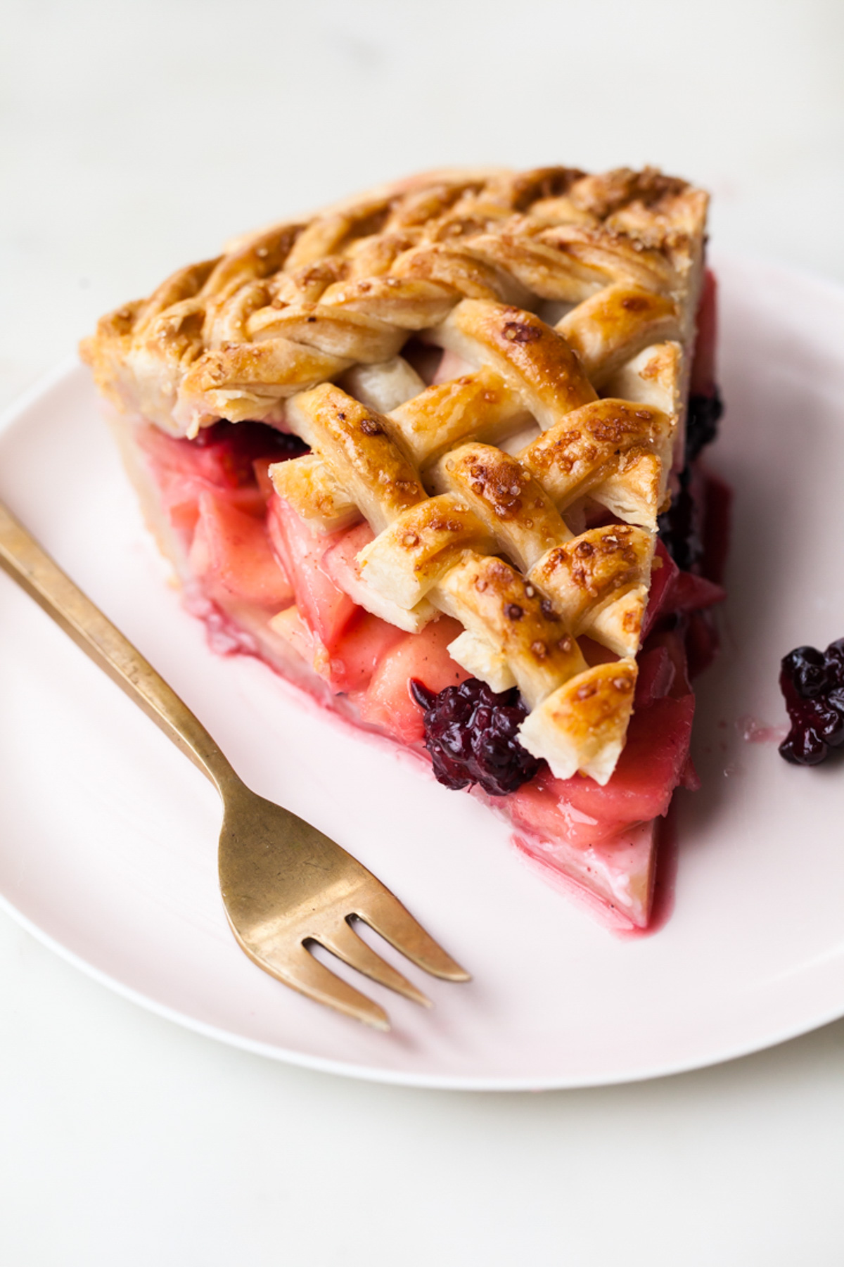 A slice of apple blackberry pie with a lattice crust