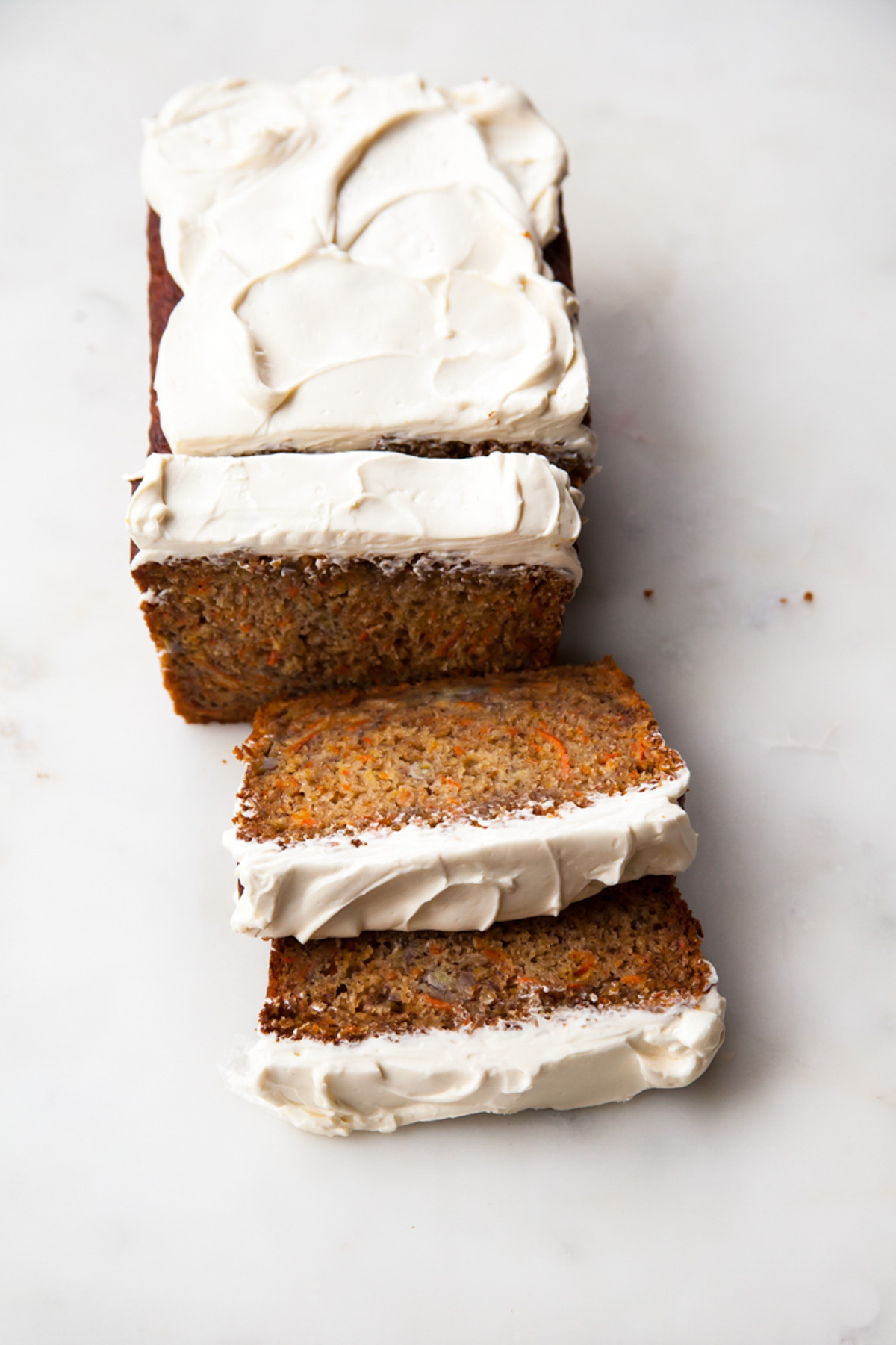 A load of carrot banana bread with cream cheese frosting that's been sliced