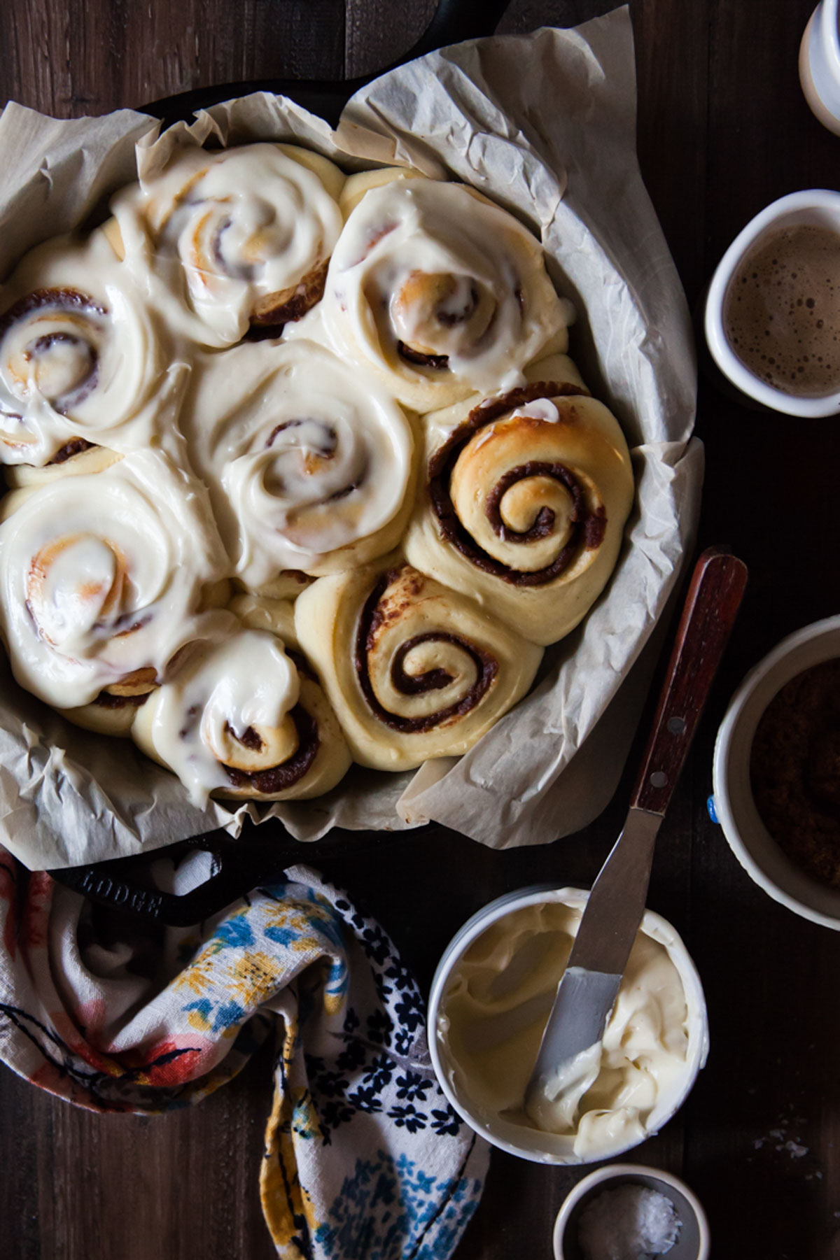 Date cinnamon rolls with  bourbon cream cheese in a cast iron pan