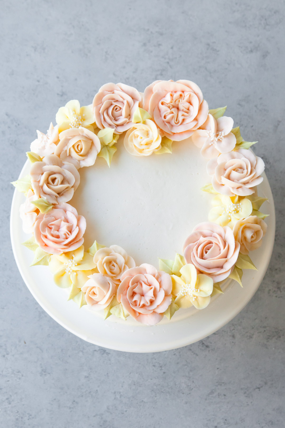 A four layer carrot cake with cream cheese frosting and beautiful buttercream roses on the top.