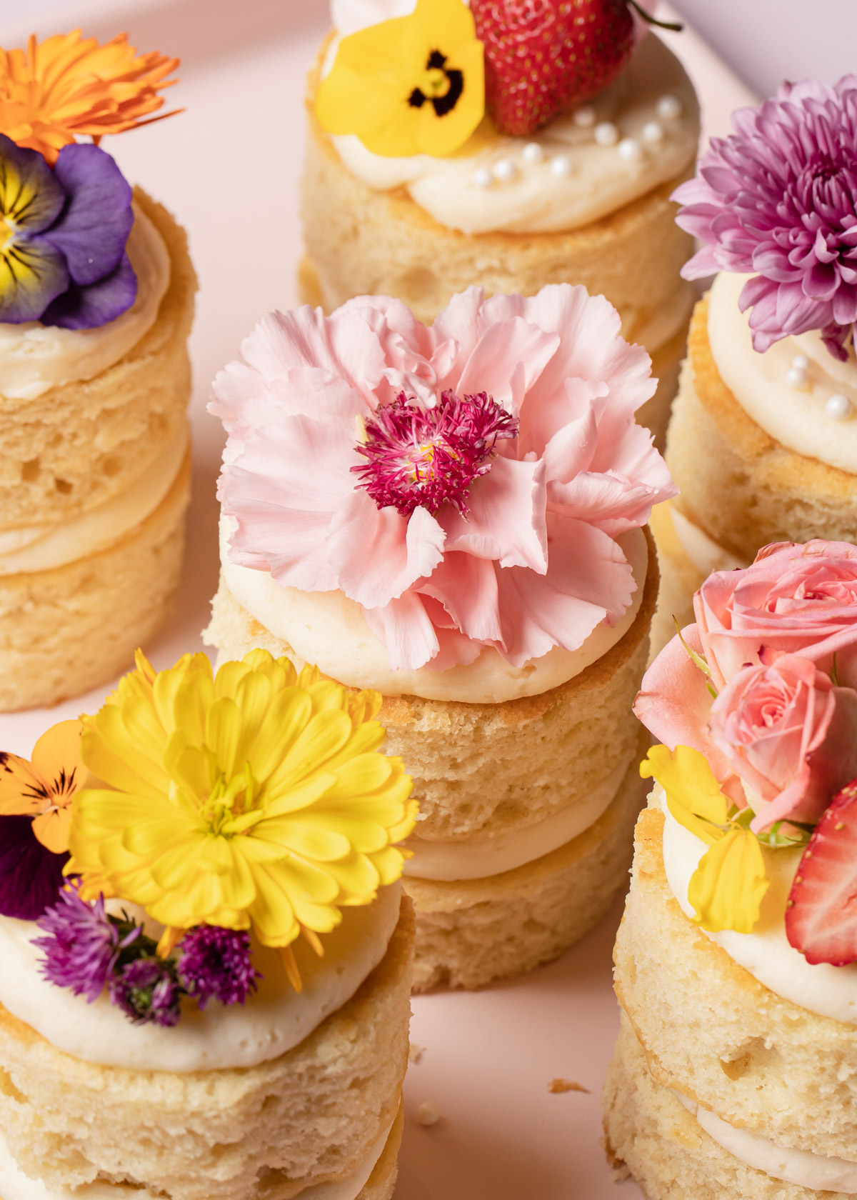 A ¾ close-up view of mini layer cakes with flowers on top