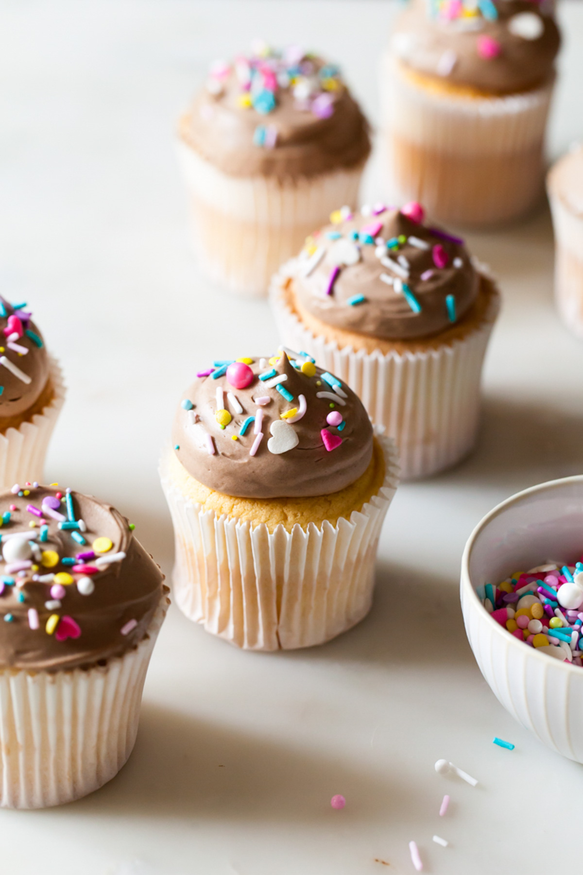 Angel food cupcakes with a mound of milk chocolate frosting on top