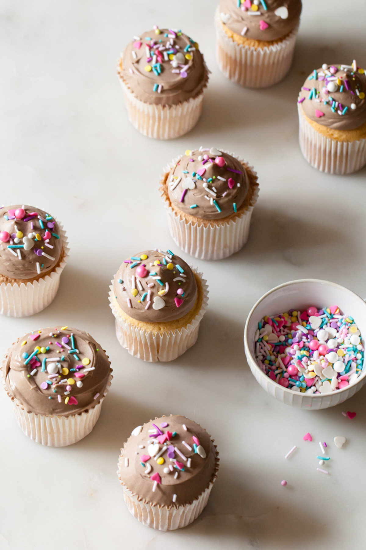 Frosted angel food cupcakes with milk chocolate and sprinkles