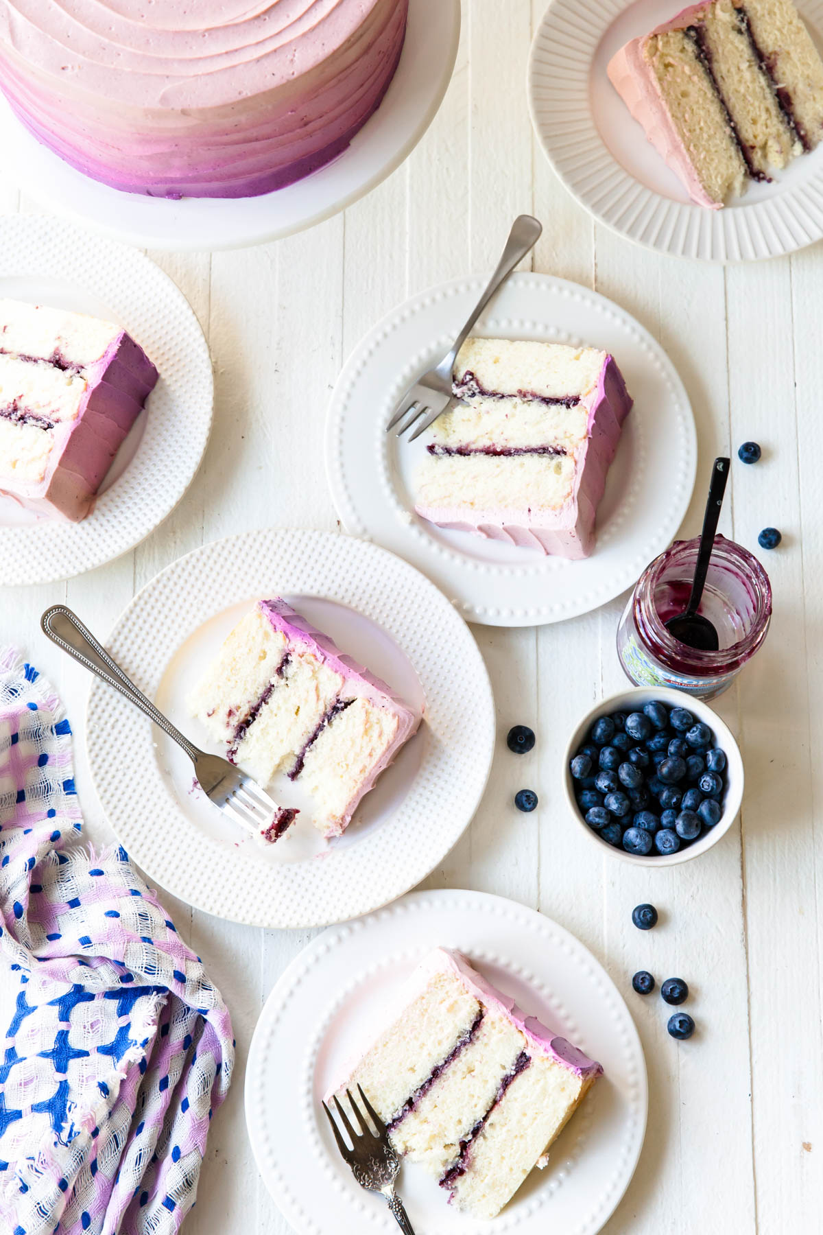 Slices of a three-layer white cake filled with blueberry jam