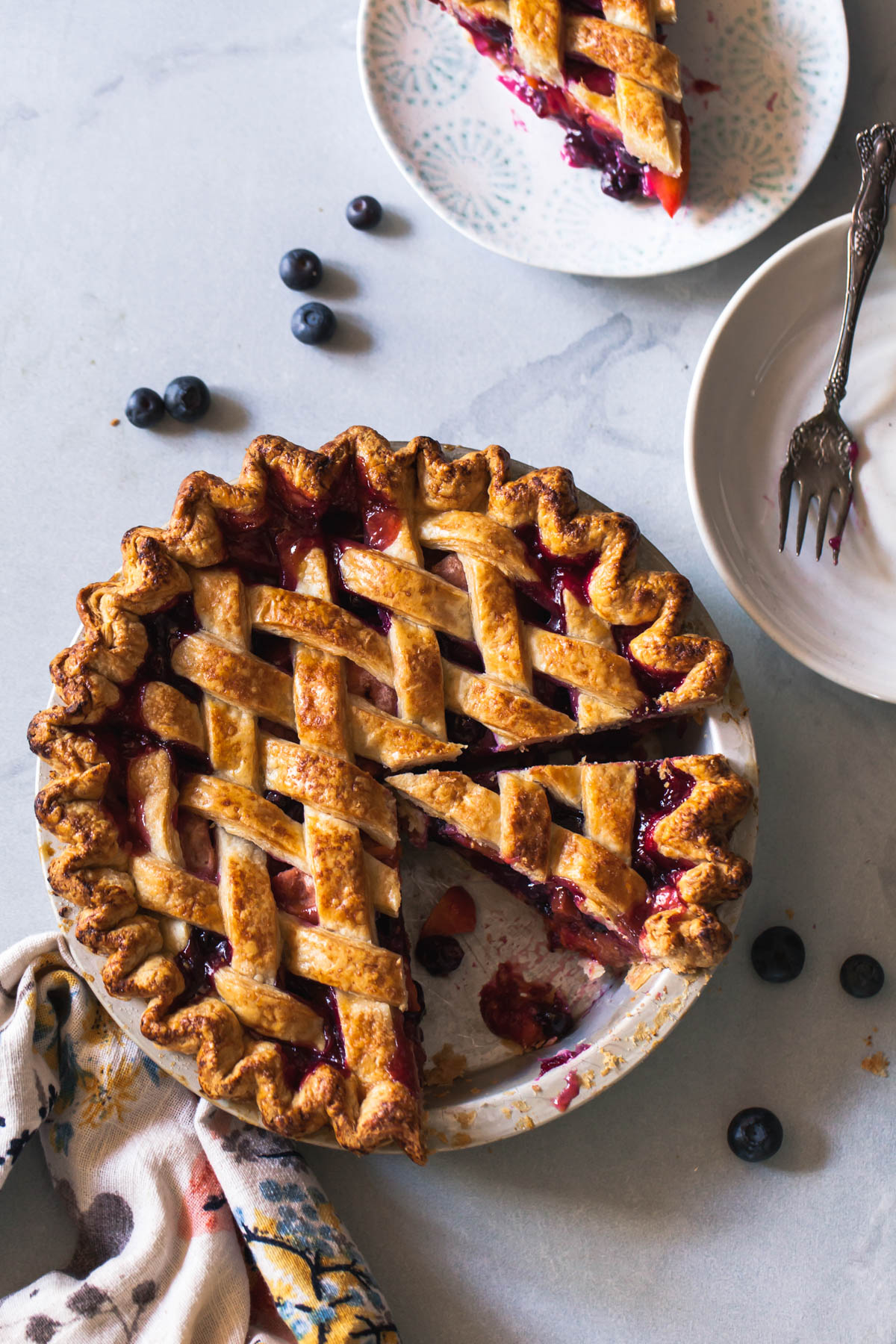 A baked and sliced blueberry peach pie