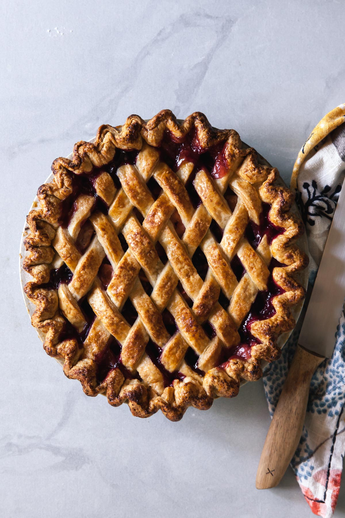 A golden brown lattice crust on a blueberry peach pit