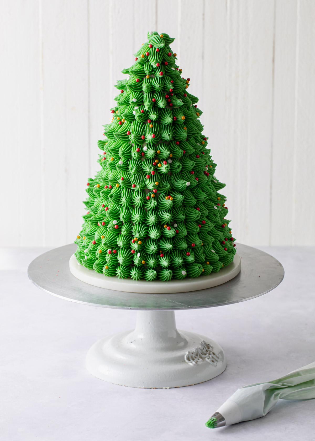A Christmas tree cake covered in piped green buttercream.
