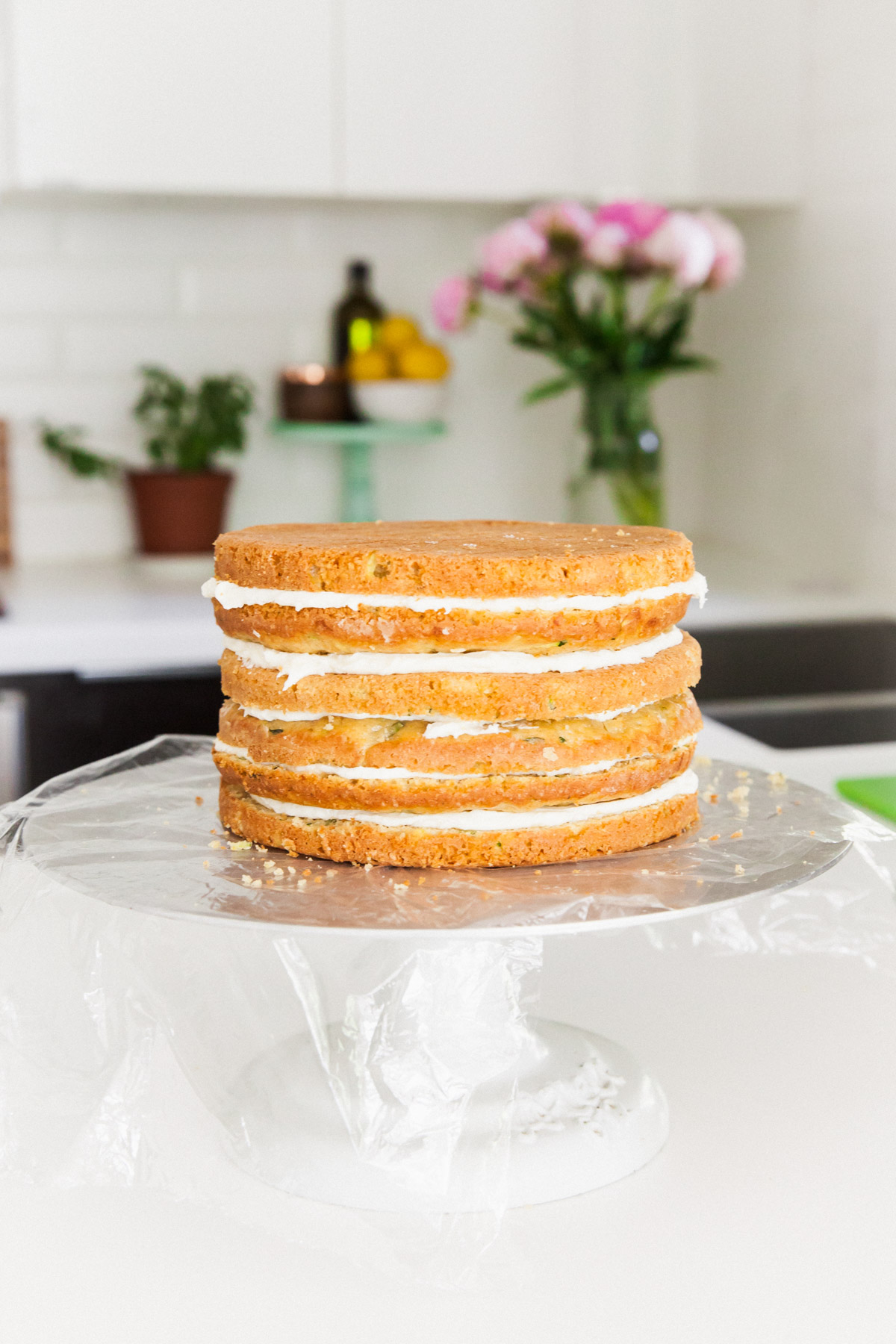 stacking a lemon zucchini cake with goat cheese frosting