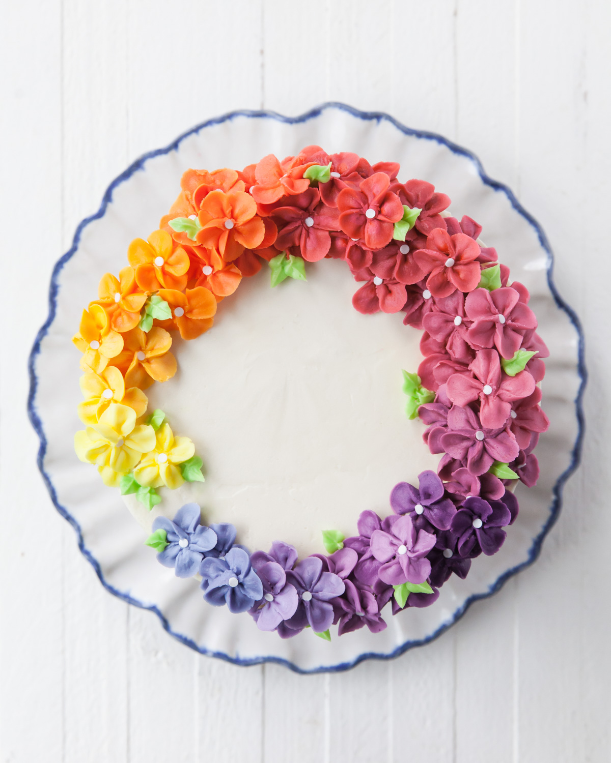 A rainbow of buttercream flowers on top of a cake