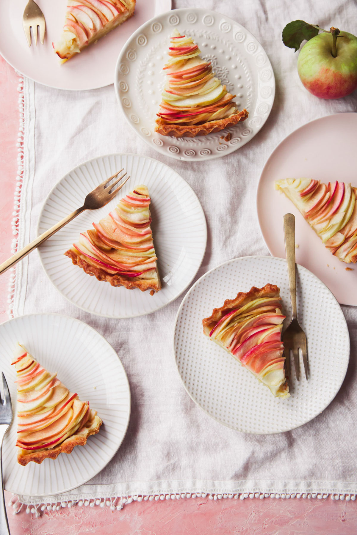 Several slices of apple tart on a white linen