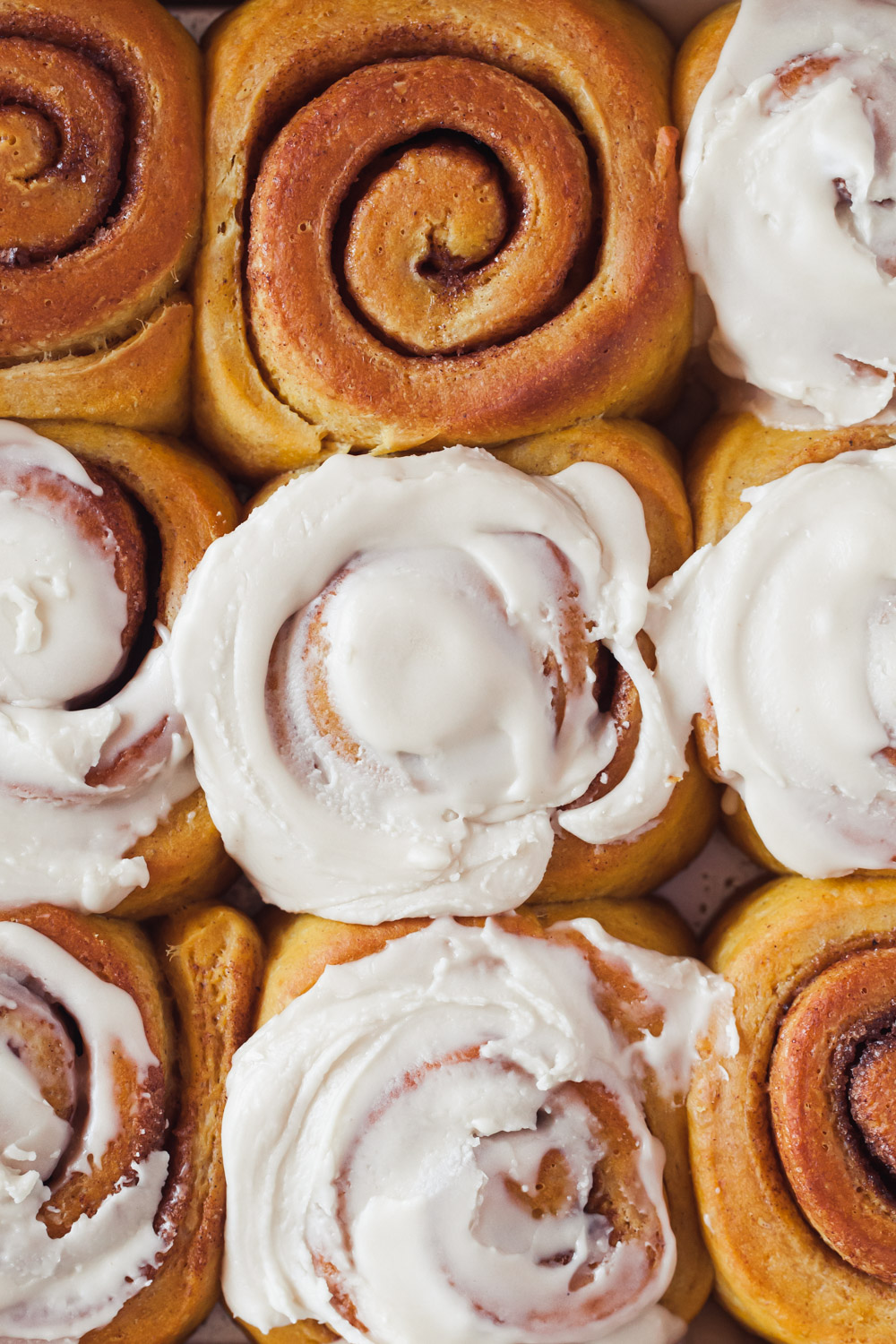 A close-up of a glazed pumpkin cinnamon roll