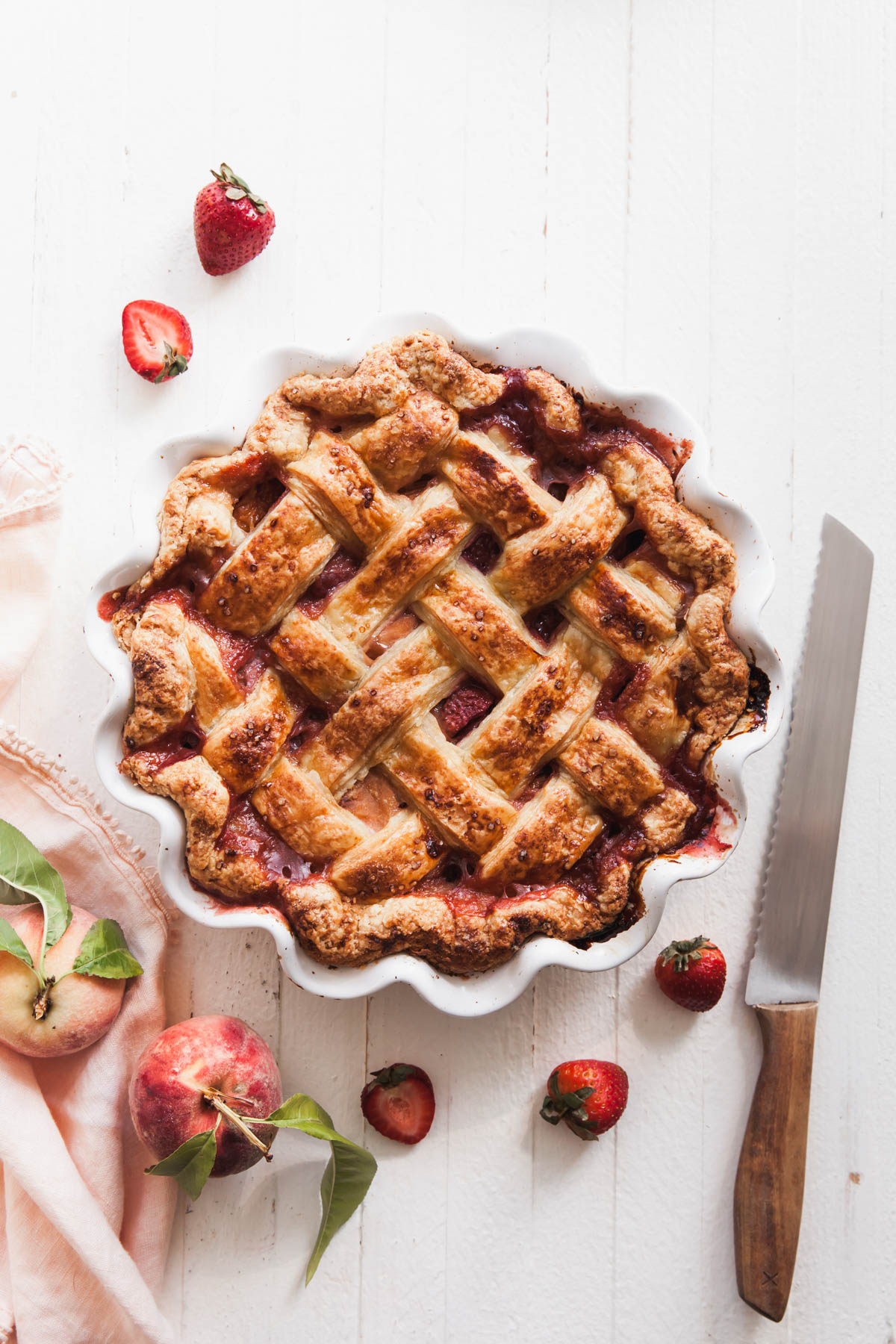 A baked peach strawberry pie with a lattice crust