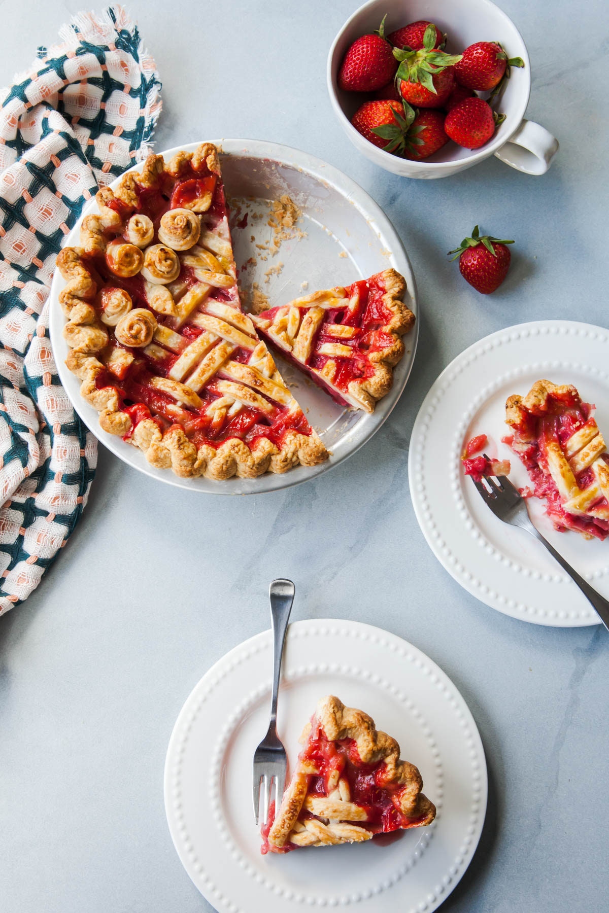 Slices of bright red strawberry rhubarb pie