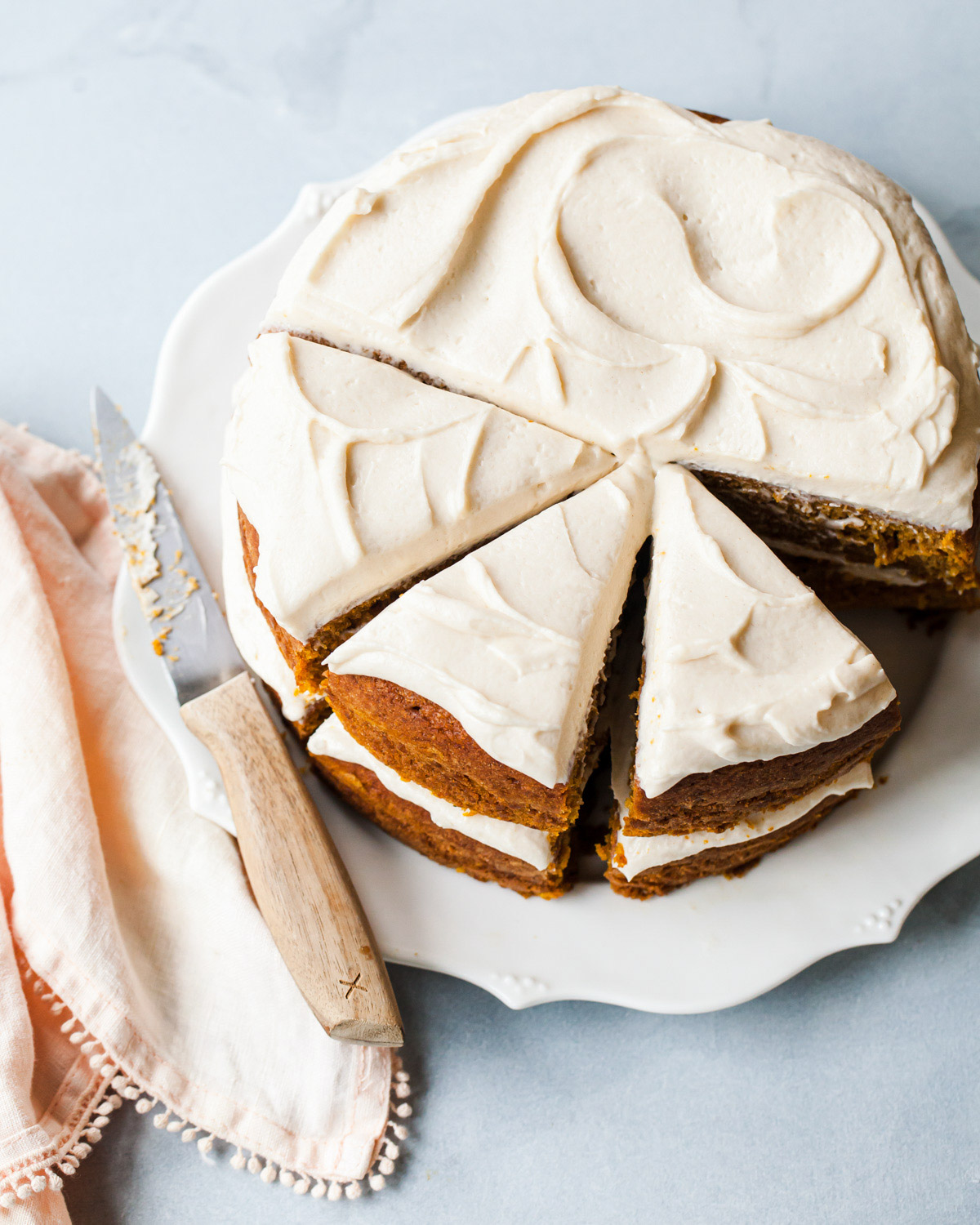 A pumpkin cake with maple cream cheese frosting sliced into pieces