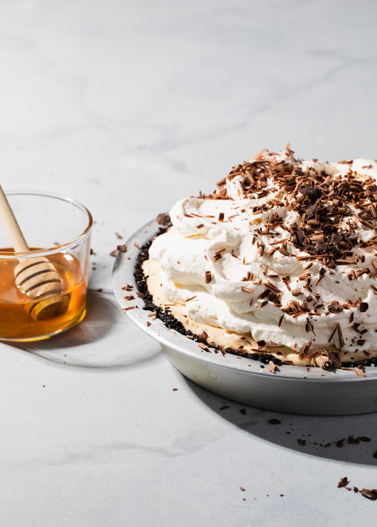 A no-bake peanut butter pie with salted honey whipped cream and chocolate shavings on top
