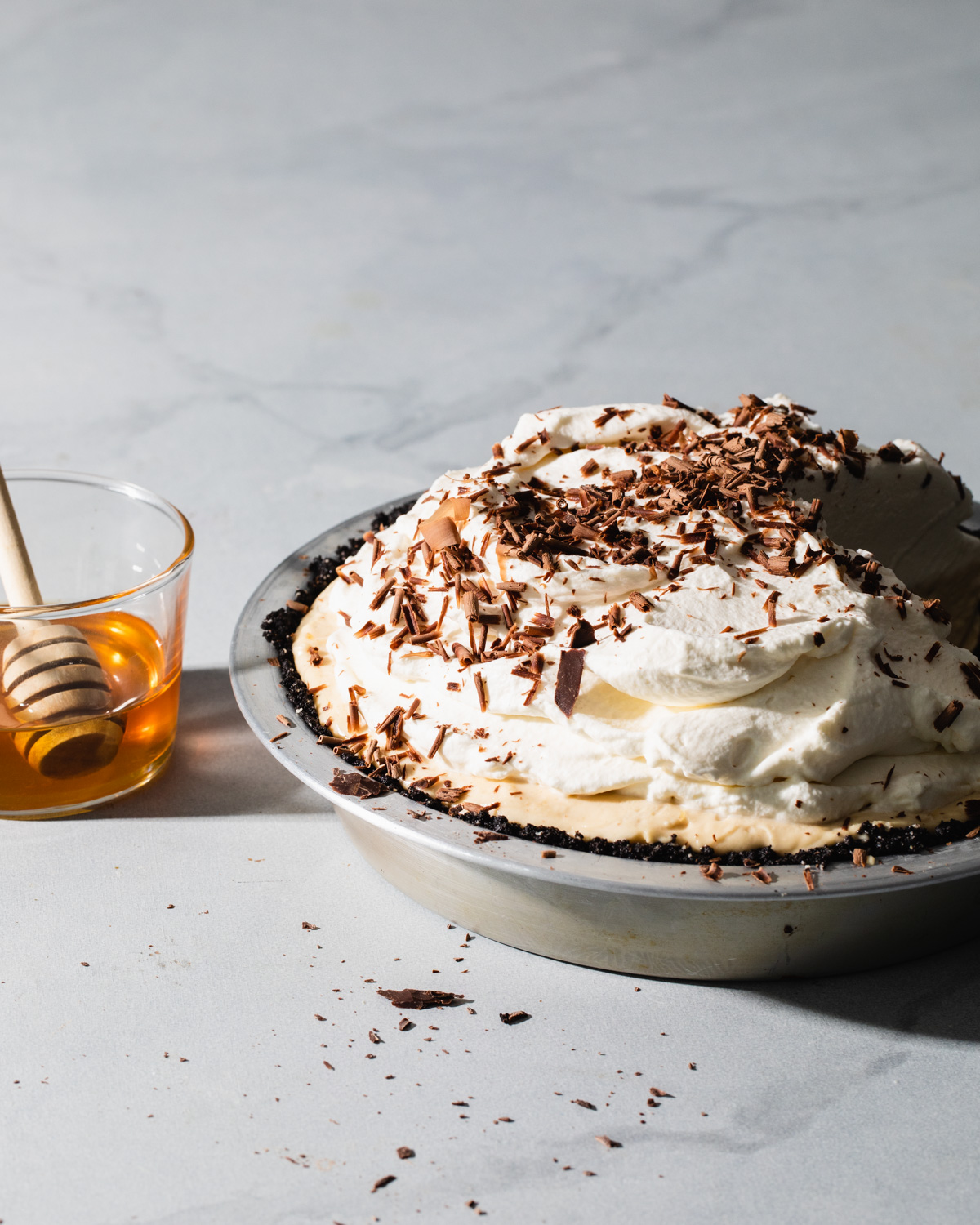 A no-bake peanut butter pie with salted honey whipped cream and chocolate shavings on top
