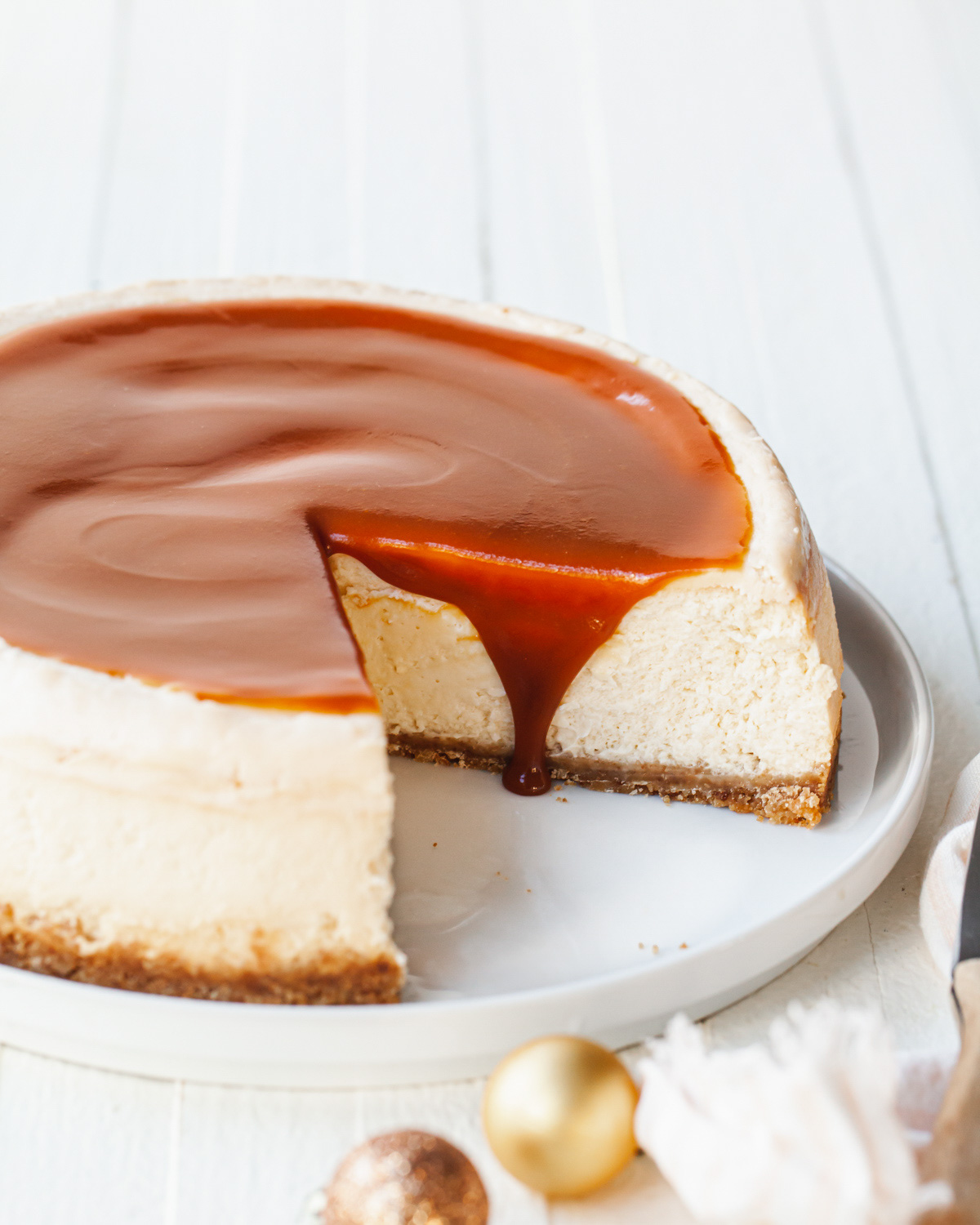A slice cheesecake with caramel sauce dripping down