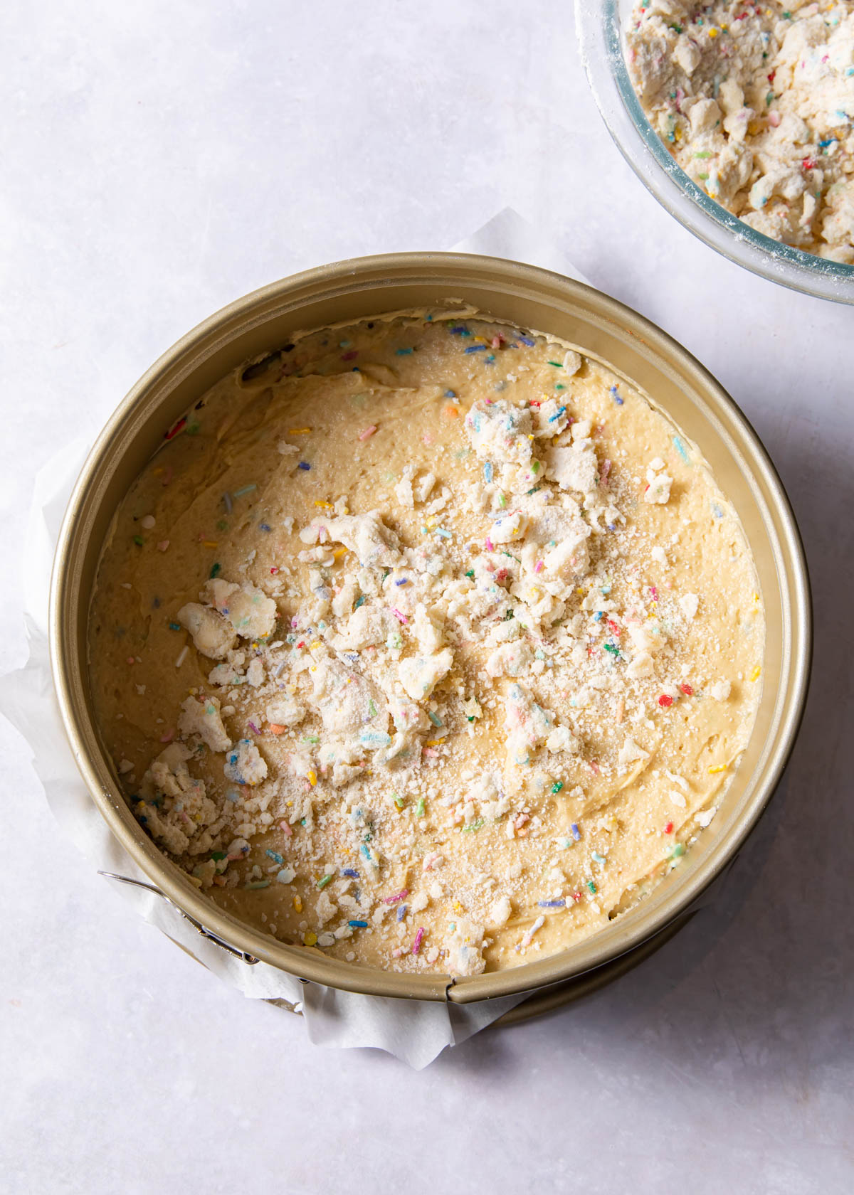 Sprinkling the crumb on top of the coffee cake batter