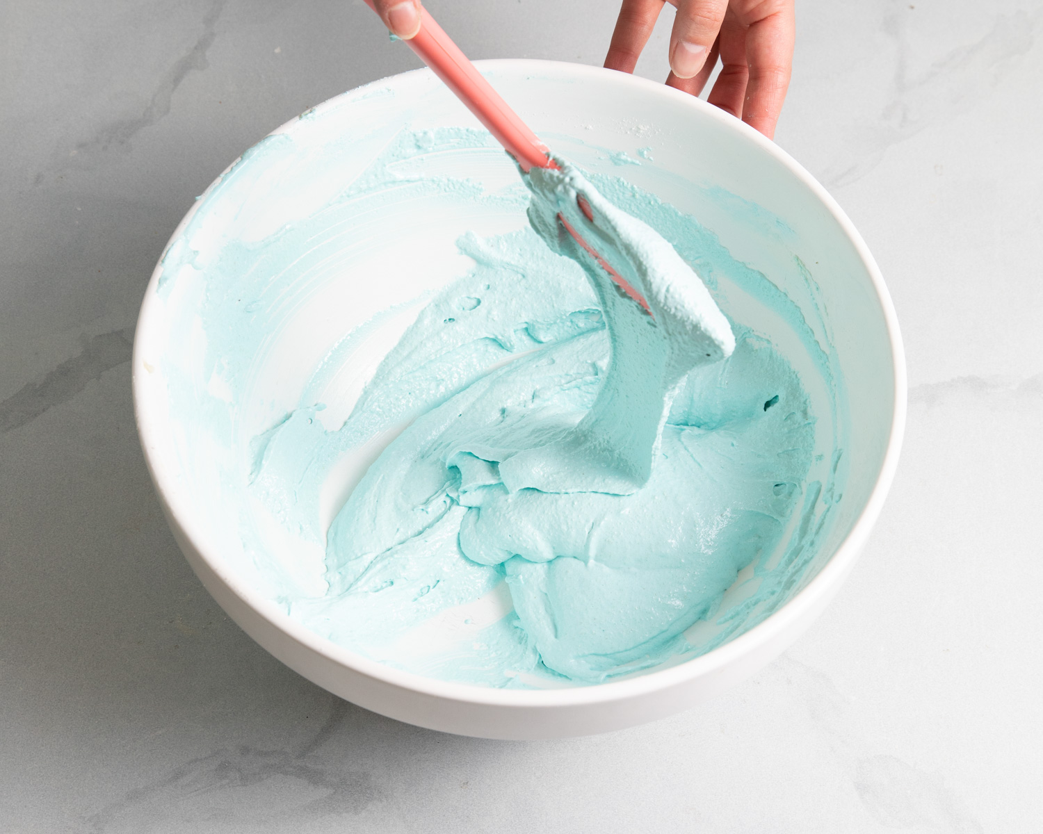 testing macaron batter with a spatula