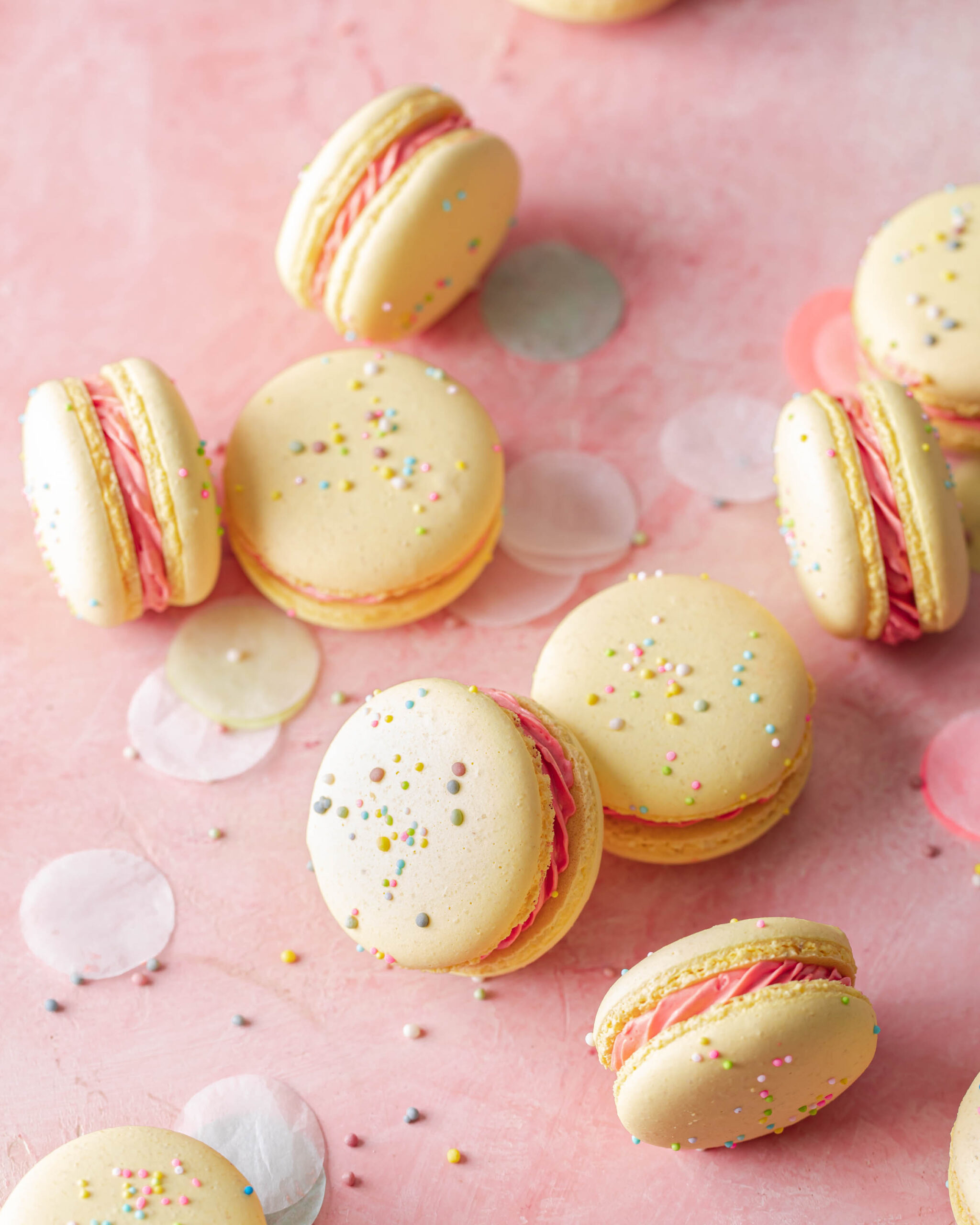 Yellow macarons with sprinkles and pink filling