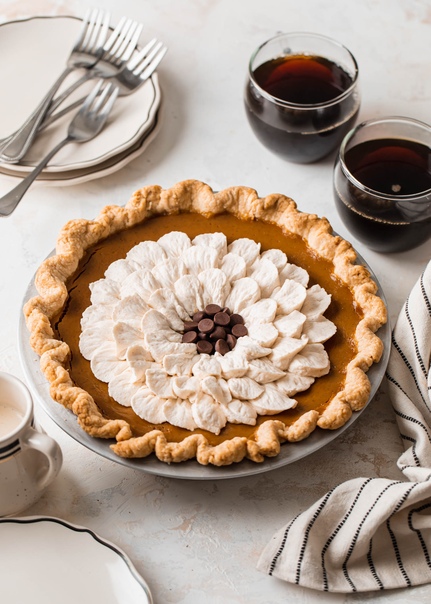 Pumpkin pie with cinnamon whipped cream made to look like a flower on top