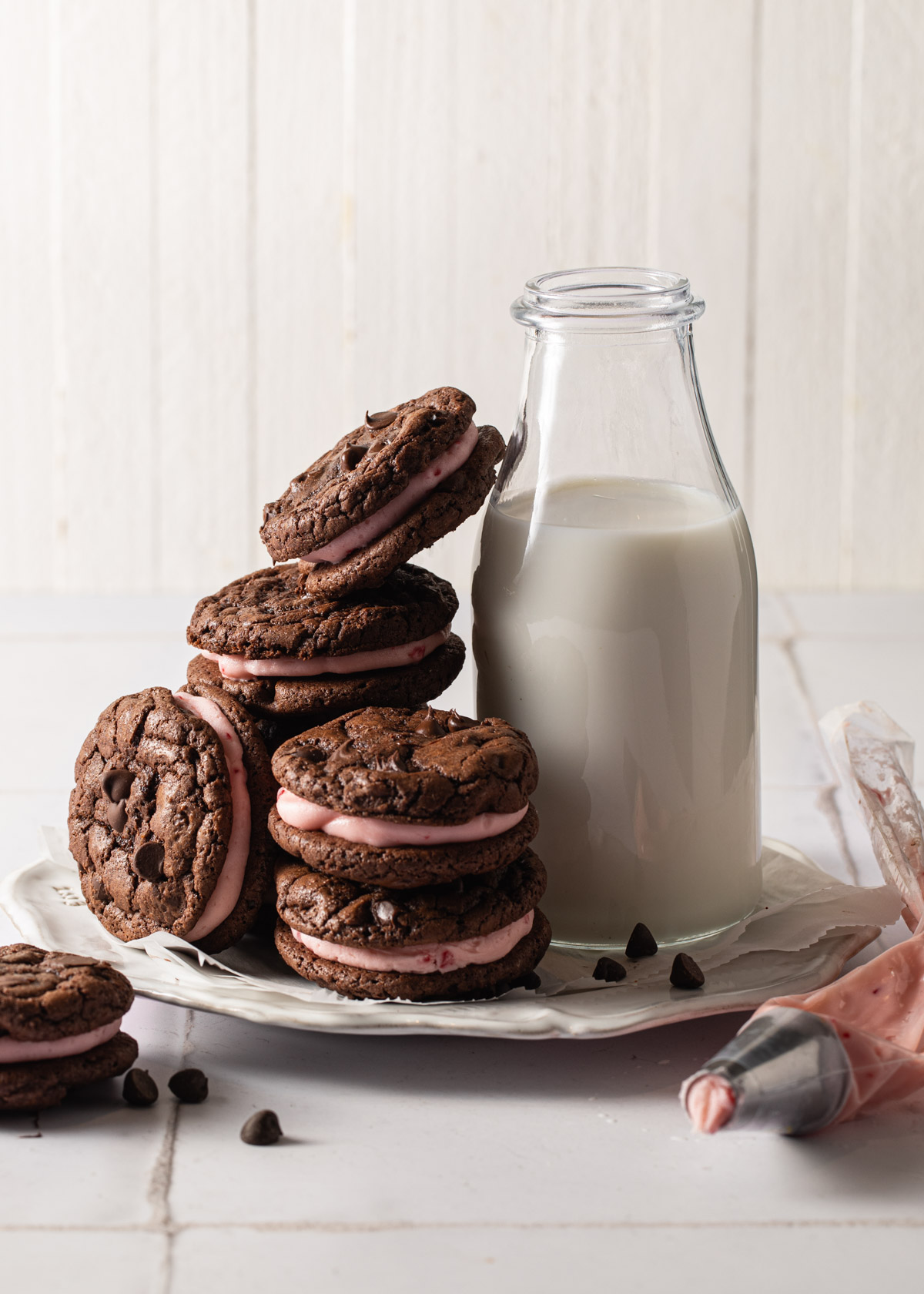 A plate of chocolate peppermint cookies with a bottle of milk