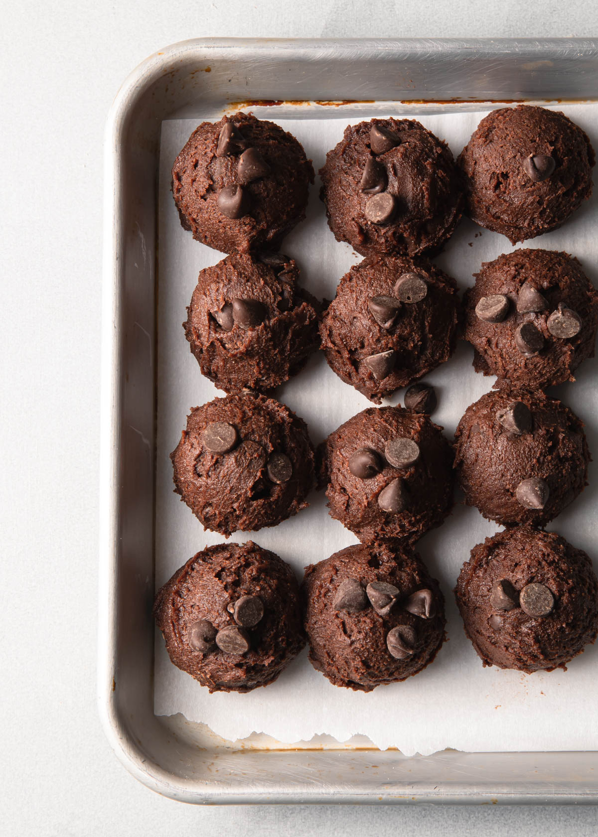 scooped double chocolate cookie dough on a baking sheet