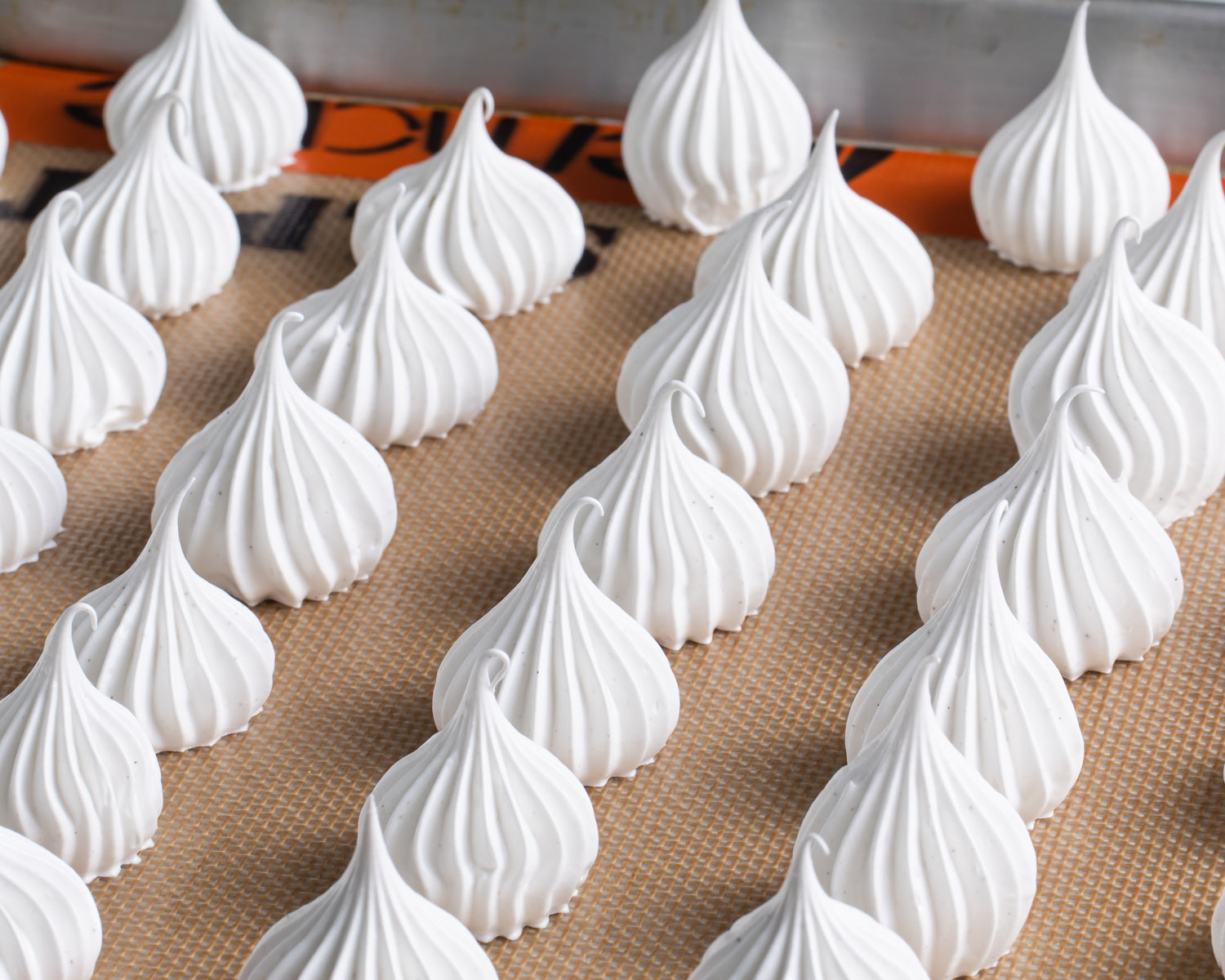 Piped meringue kisses before baking