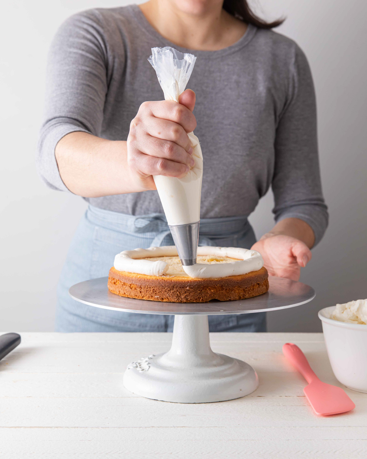 Piping a buttercream dam while stacking a layer cake