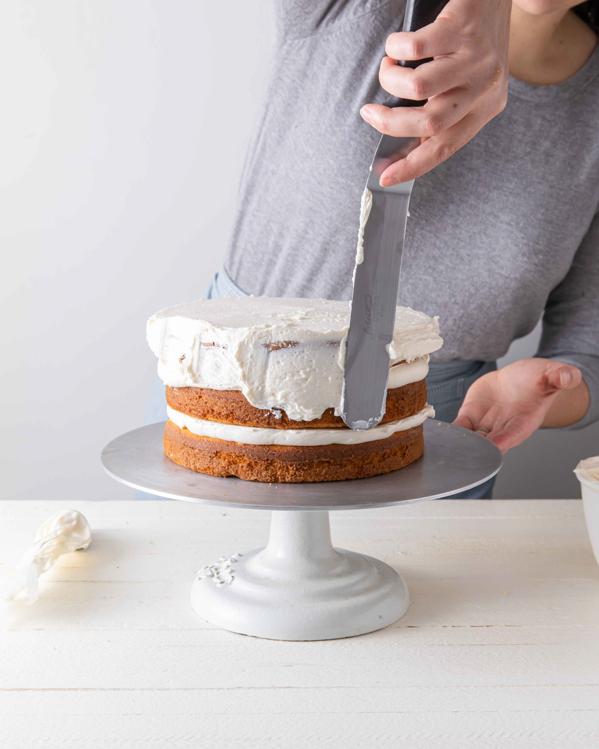 Spreading the crumb coat on layer cake