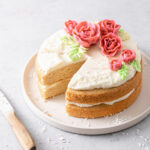 An almond layer cake with cream cheese frosting and buttercream roses on top
