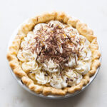Banana cream pie with piped whipped cream and chocolate shavings on top