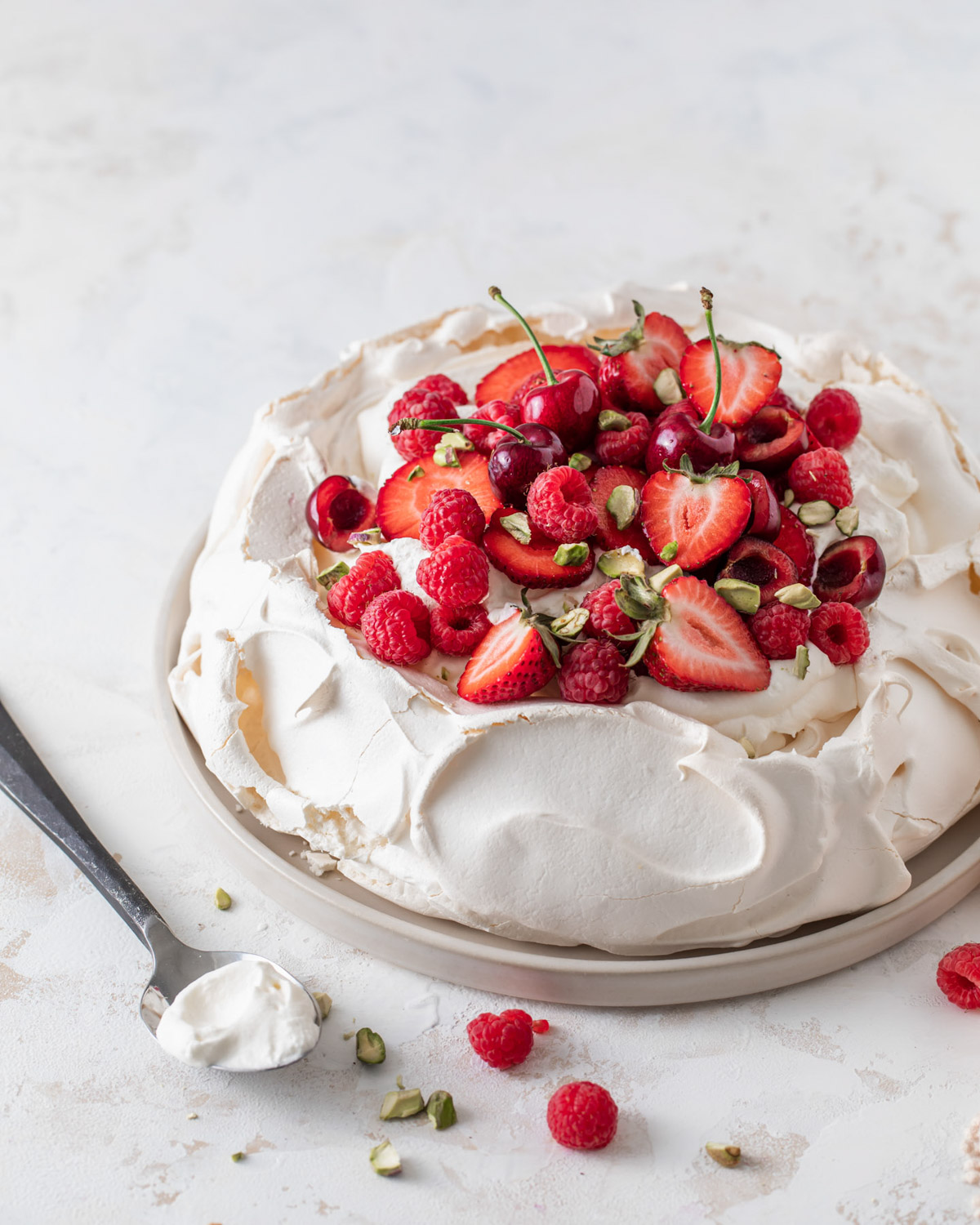 A bake pavlova with whipped cream on top and fresh berries