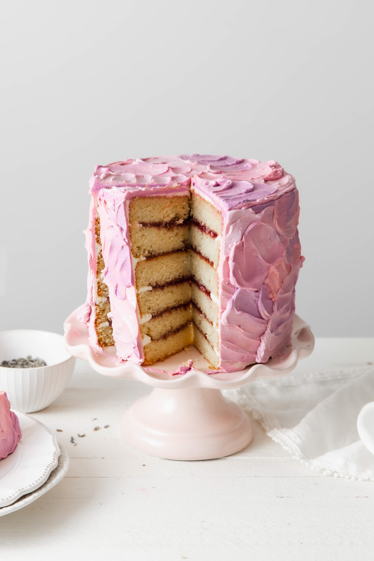 6-layer blackberry lavender cake on a pedestal that has been sliced