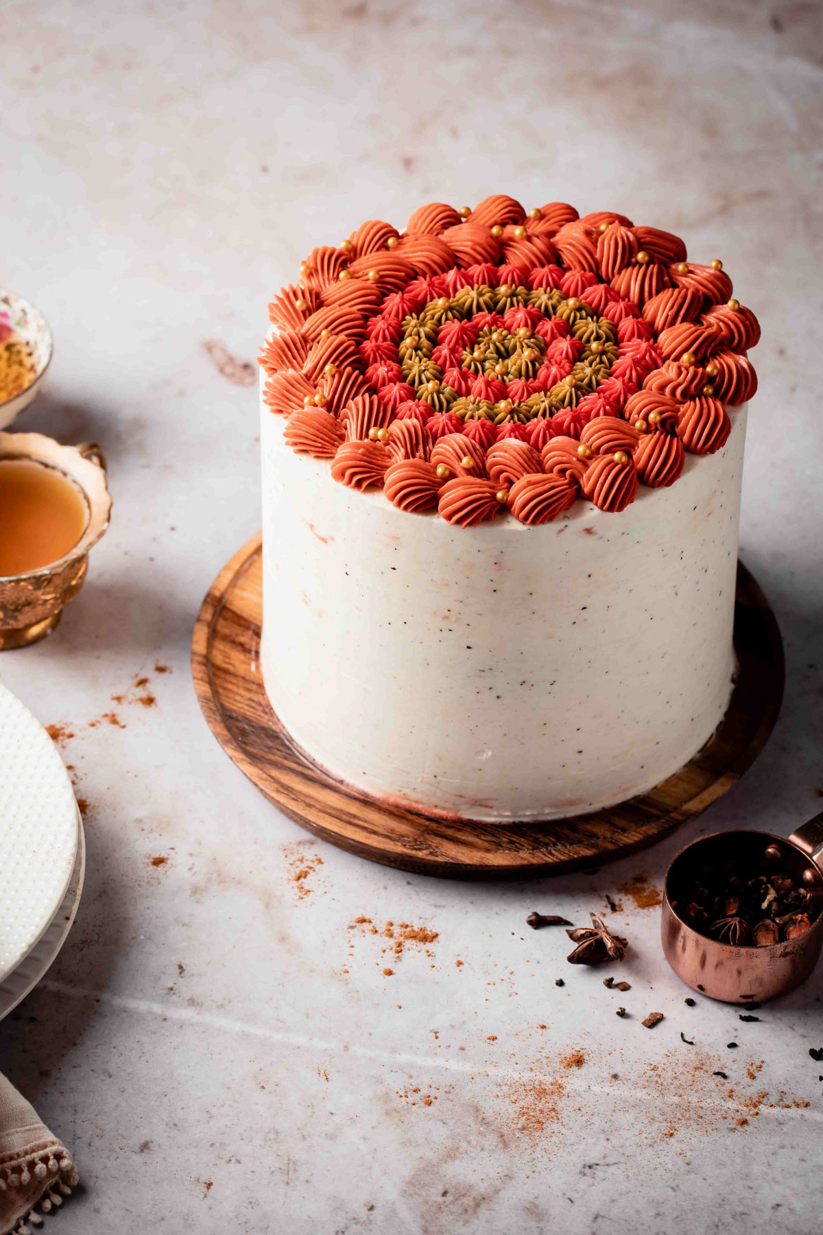 A chai spice cake with red and orange piped buttercream on top