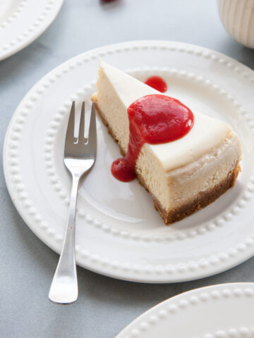 A slice of vanilla cheesecake with rhubarb sauce