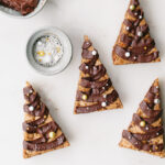 Chocolate chip cookie bars that are shaped like Christmas trees and frosted with chocolate ganache