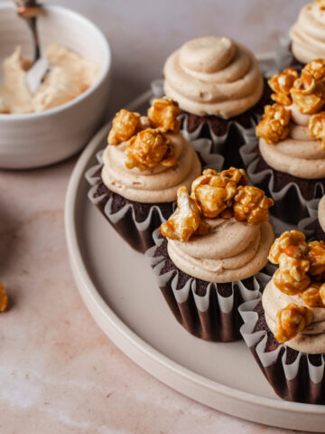 Chocolate cupcakes with swirls of peanut butter frosting on top and caramel corn.