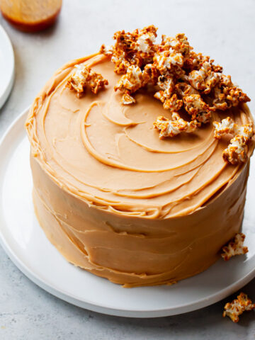 A chocolate stout layer cake iced with caramel frosting and caramel popcorn on top