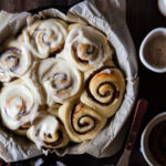 Baked cinnamon rolls with date filling and bourbon cream cheese on top