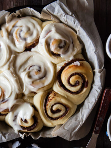 Baked cinnamon rolls with date filling and bourbon cream cheese on top