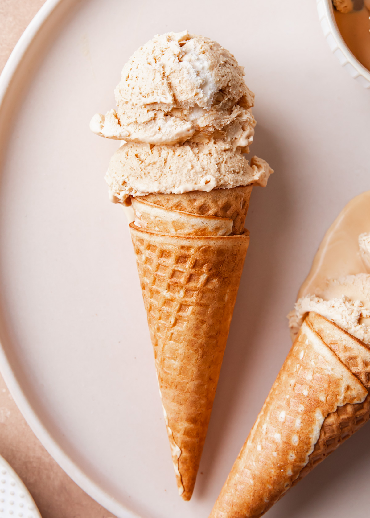 A close-up of an ice cream cone with two scoops of dulce de leche ice cream
